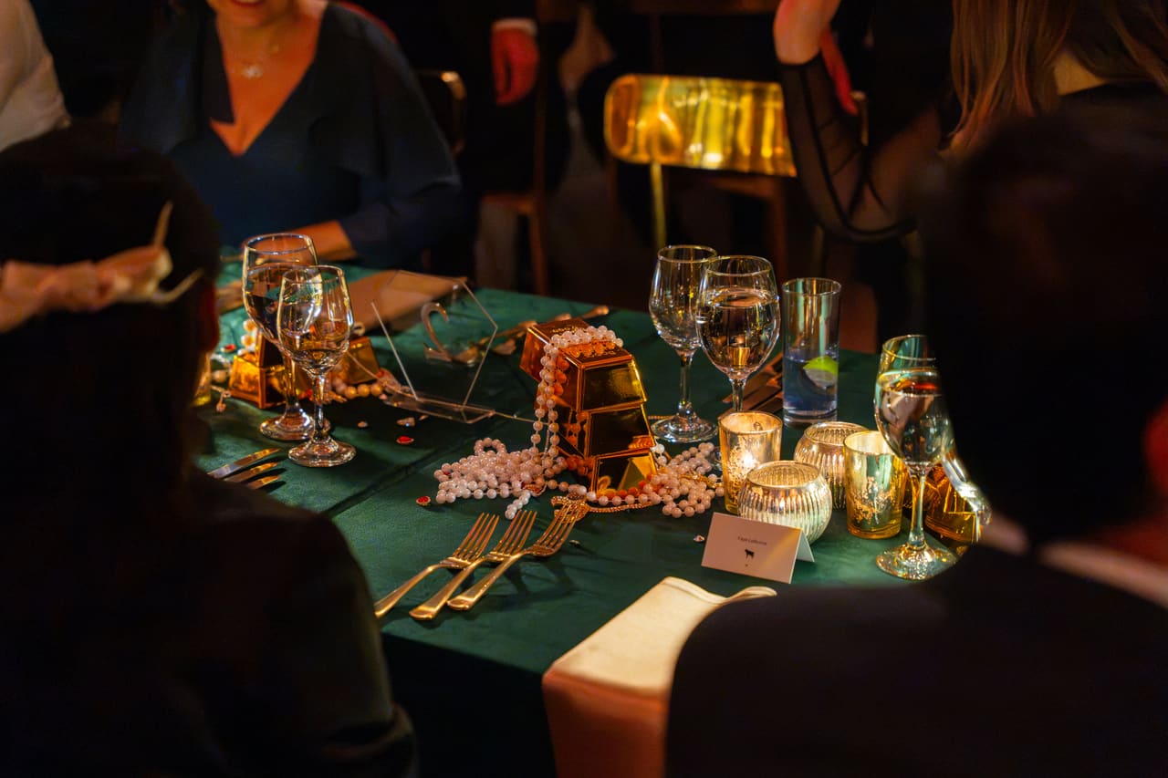 A gala table set with candles, glassware and gilded decorations
