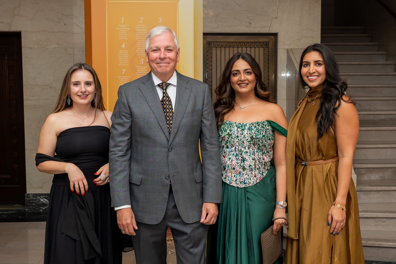 Four colleagues in evening wear posing together at the gala