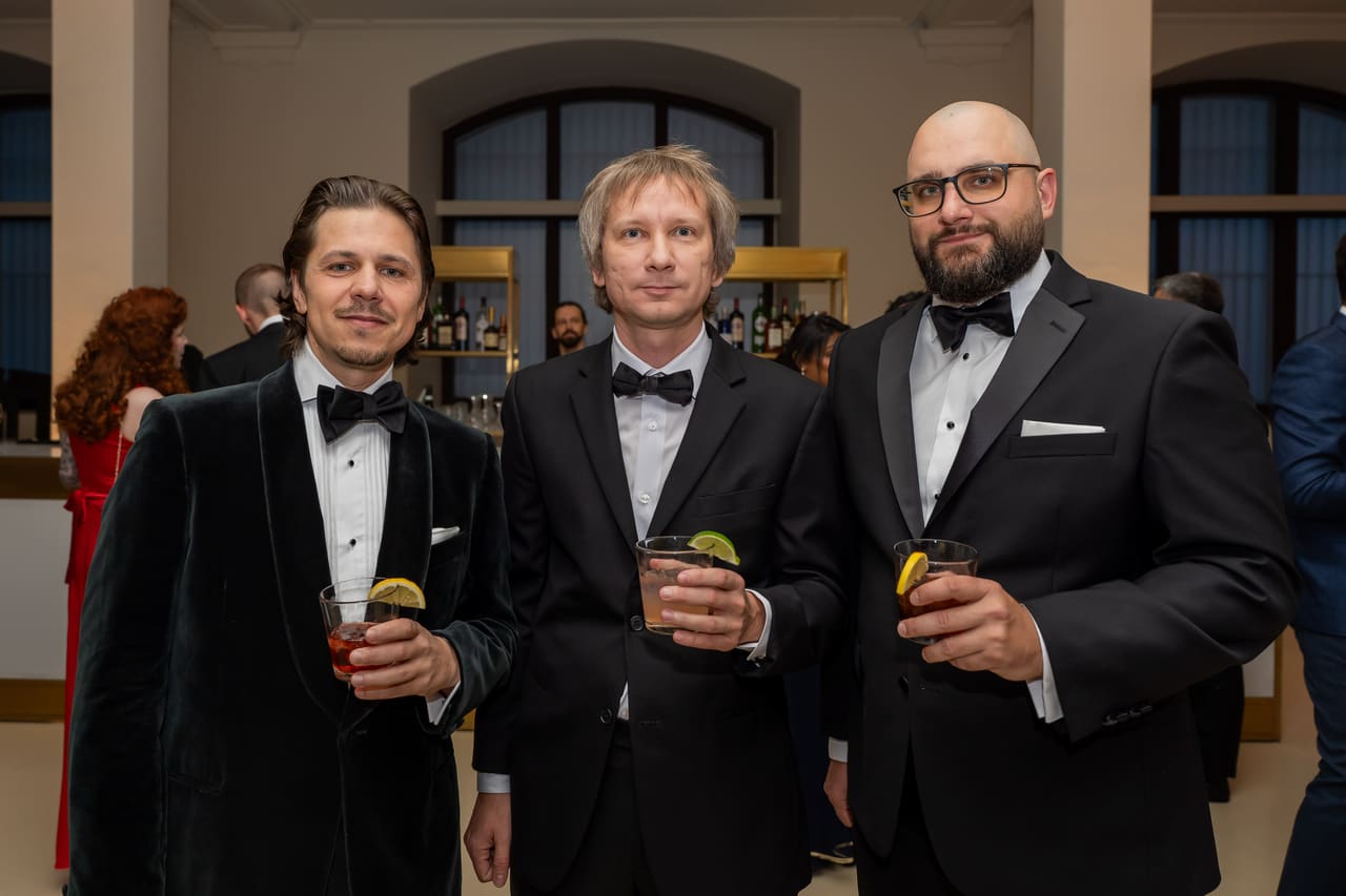 Three colleagues in dinner jackets raising a toast at the gala