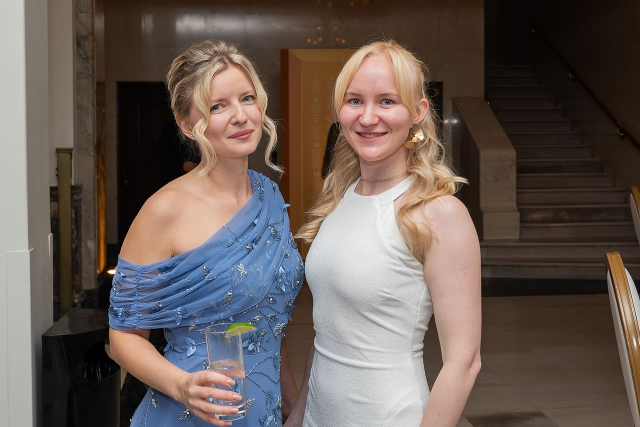 Two colleagues in evening dresses smiling at the gala