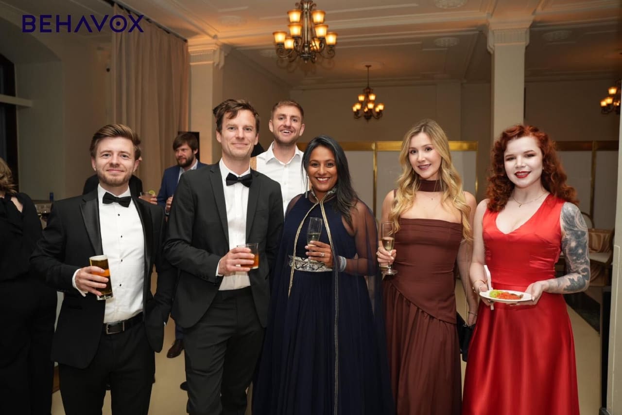 A group of colleagues in evening wear under the Behavox logo